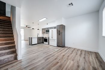 an empty kitchen and living room with white walls and wood floors